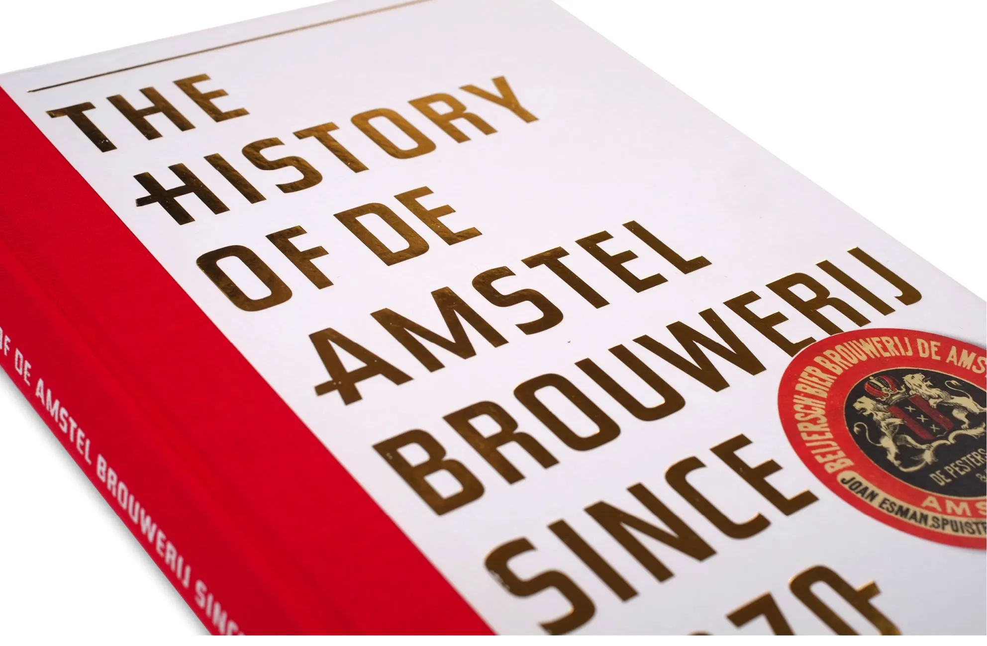 Close-up of the book spine and cover with gold lettering 'The history of de Amstel brouwerij since 1870'