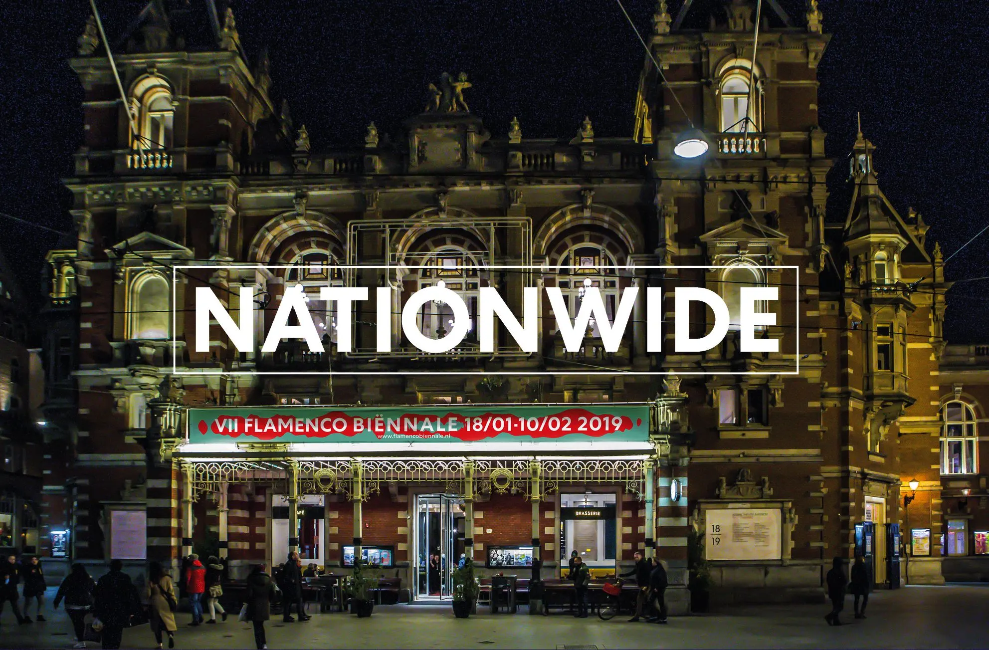 Illuminated historic theatre facade at night with a Flamenco Biënnale banner and the word Nationwide