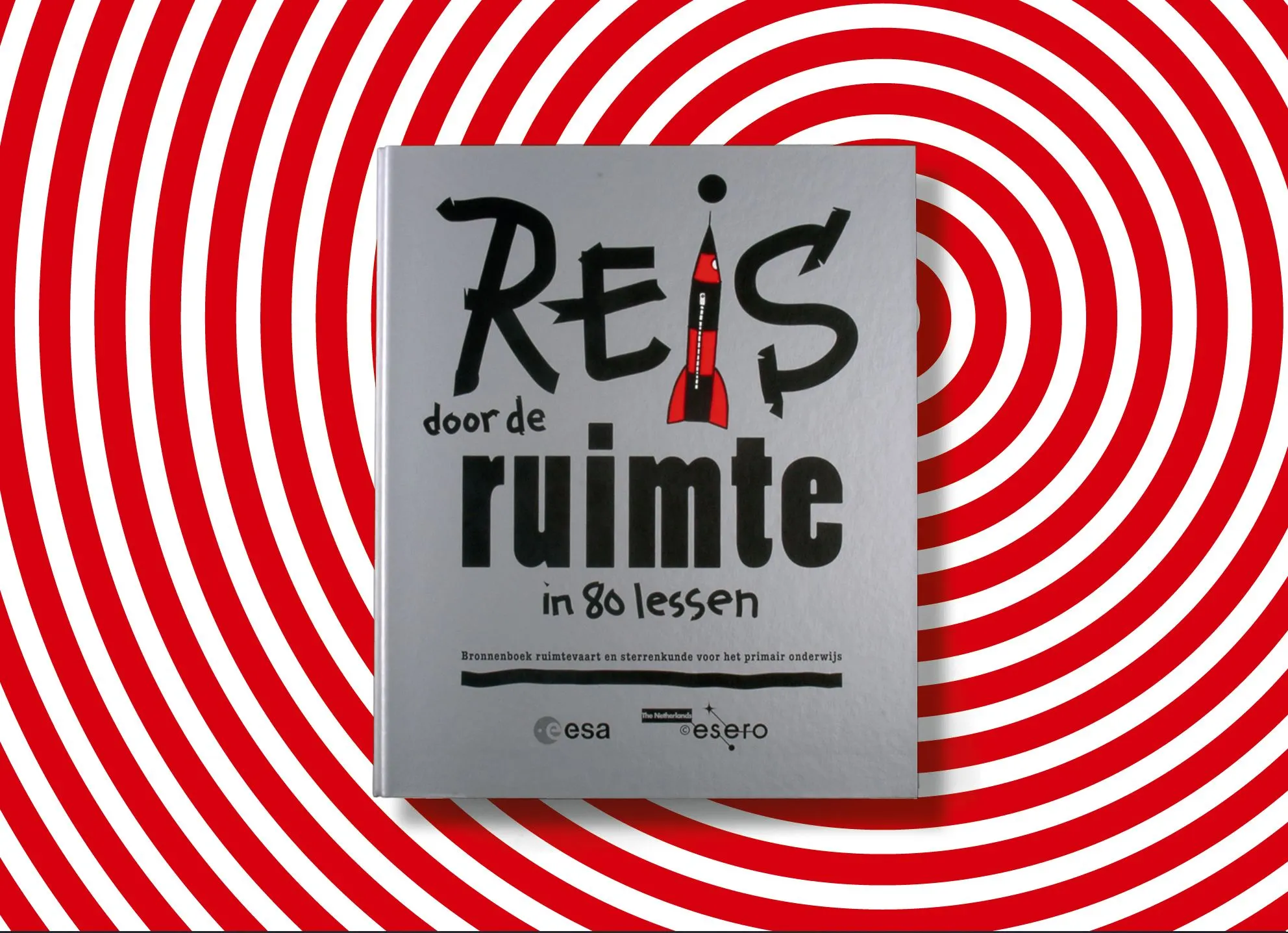 Silver binder ‘Reis door de ruimte in 80 lessen’ on a red and white concentric spiral background, with ESA and ESERO logos