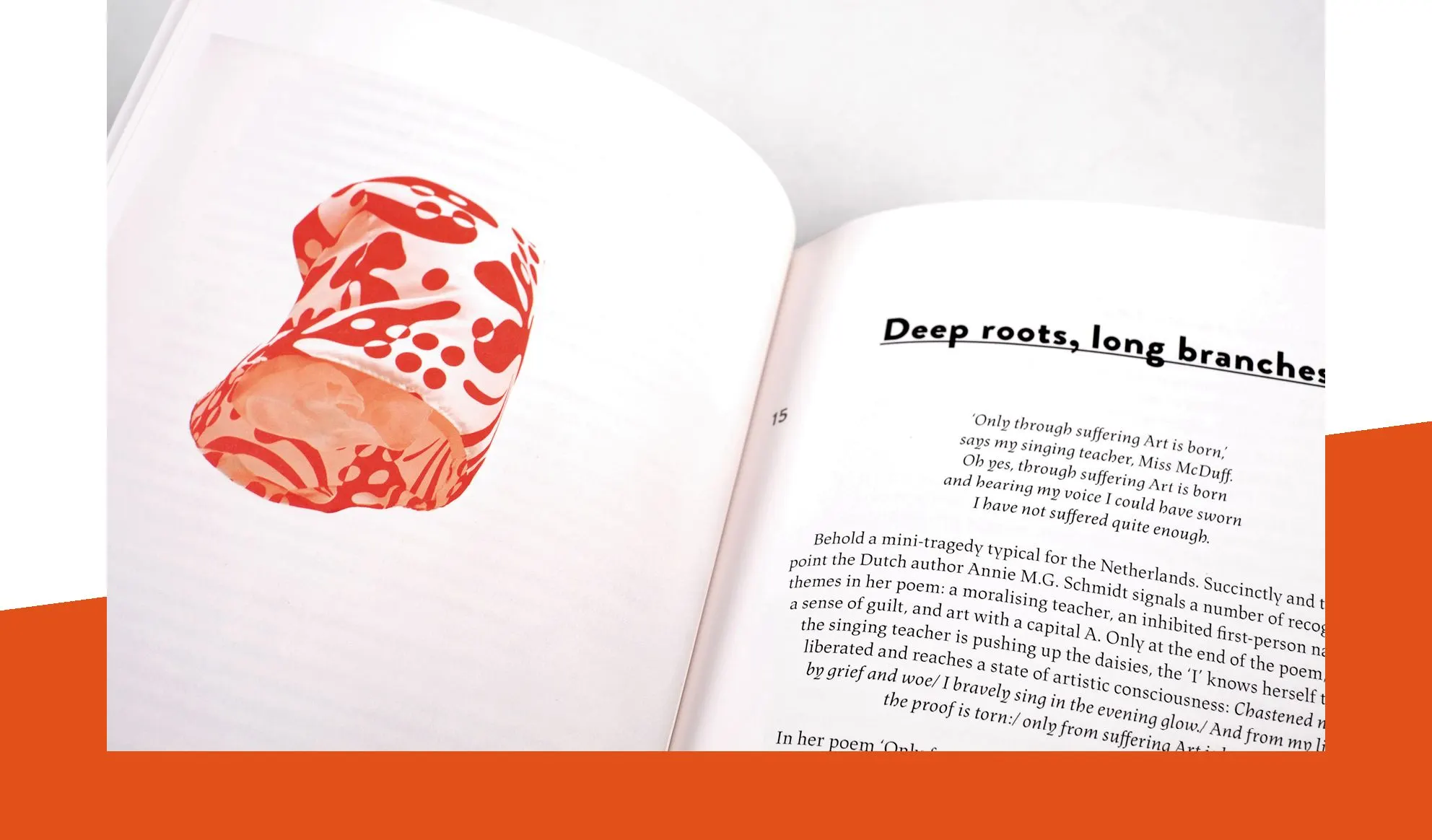 Book spread titled Deep roots, long branches with a poem and a red patterned fabric object on an orange band