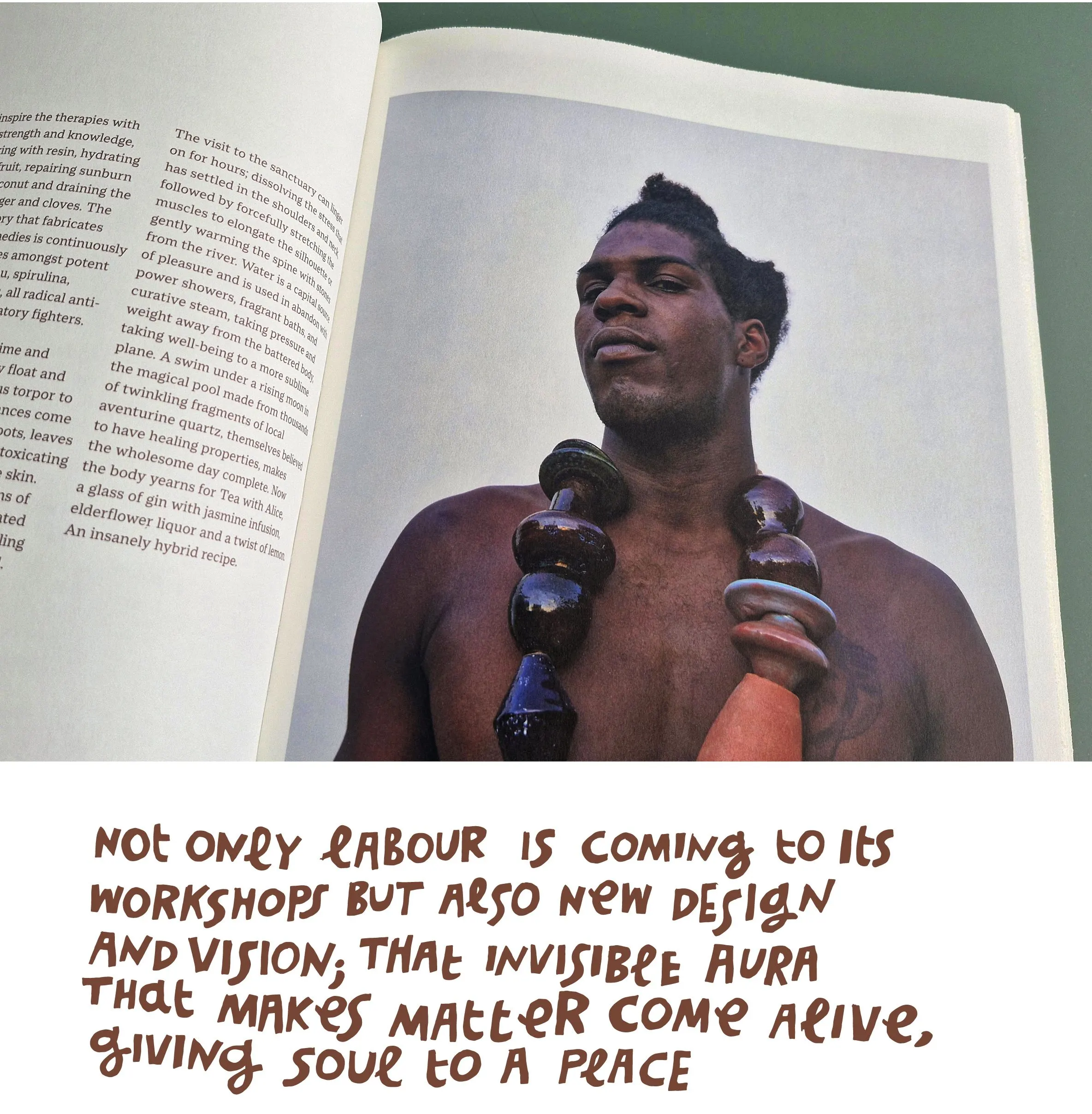 Open book with a portrait of a man wearing large dark beads, and a handwritten quote on labour, design and vision